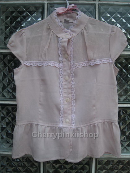 เสื้อสีชมพูอ่อน แขนตุ๊กตาเล็กๆ เย็บลูกไม้ที่คอเสื้อ ใส่แล้วดูเป็นสาวหวานน่ารัก