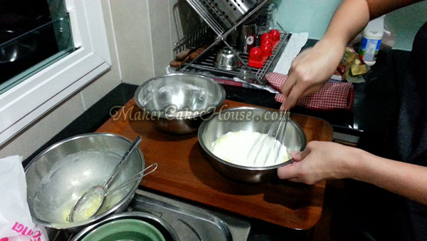 การคนส่วนผสมหลังจากใส่แป้งในส่วนผสมนม เพื่อทำซูเฟล่ชีสเค้กญี่ปุ่น